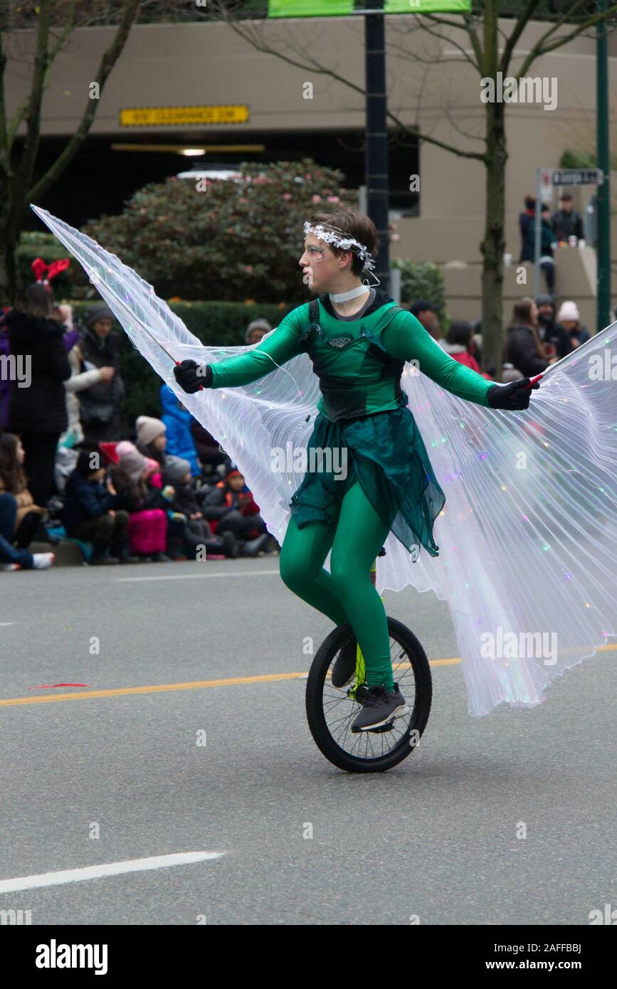 Vancouver, Canada - 1 décembre 2019 : une fille est monté sur un monocycle durant la parade annuelle du Père Noël Banque D'Images