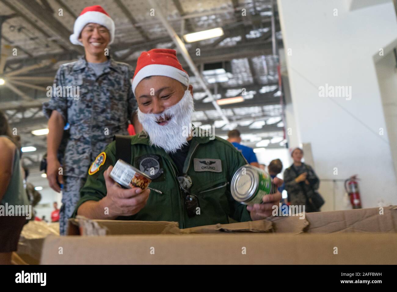 Japan Air Self-Defense Force pack aviateurs de la nourriture et des fournitures dans une caisse de fret en préparation pour l'opération de largage de Noël à la base aérienne d'Andersen 7 décembre 2019 à Agafo Gumas, Guam. Au cours des 68-ans, la U.S. Air Force Operation Christmas Drop a fourni des fournitures essentielles à 56 îles micronésiennes, touchant environ 20 000 personnes à travers un 1,8 million de milles marins carrés. Banque D'Images