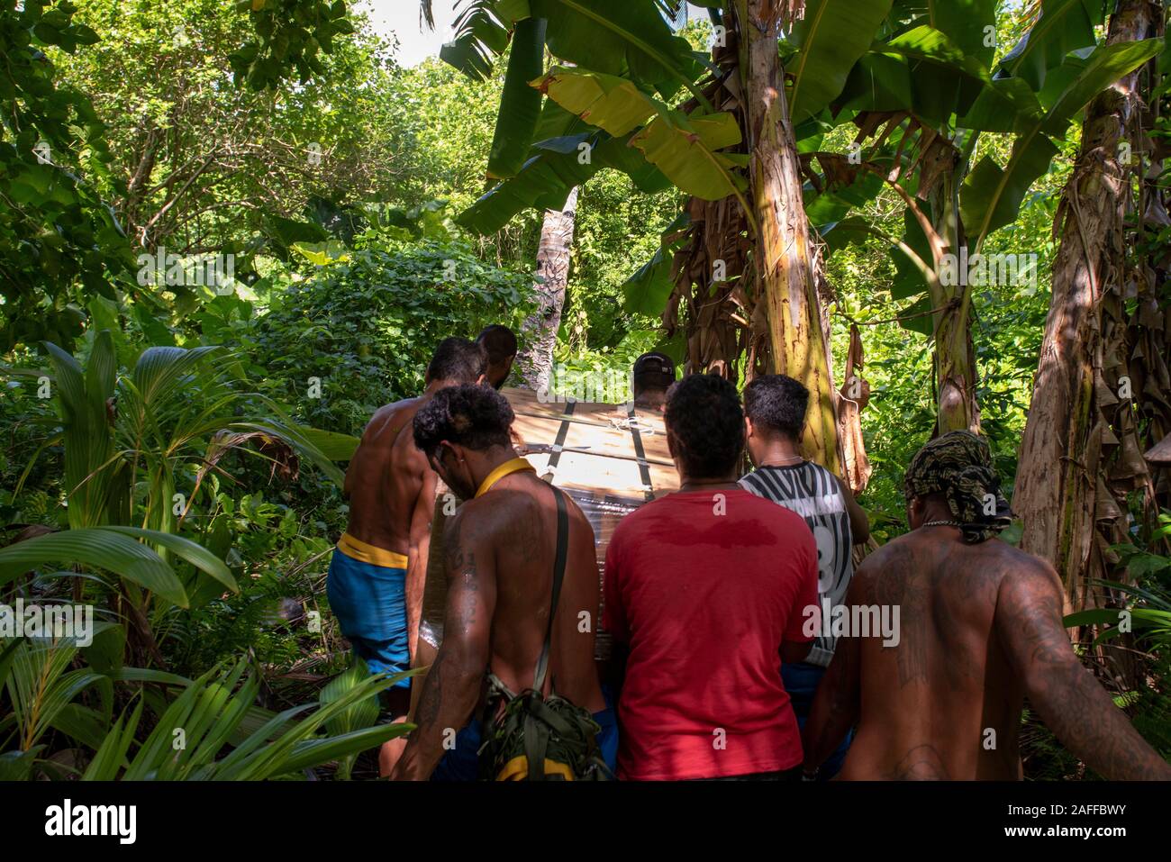 Un groupe de villageois transporter un colis contenant des marchandises et fournitures air cadeaux abandonnée par la U.S. Air Force au cours de l'Opération Goutte de Noël 10 décembre 2019, Woleai dans les États fédérés de Micronésie. Au cours des 68-ans, la U.S. Air Force Operation Christmas Drop a fourni des fournitures essentielles à 56 îles micronésiennes, touchant environ 20 000 personnes à travers un 1,8 million de milles marins carrés. Banque D'Images