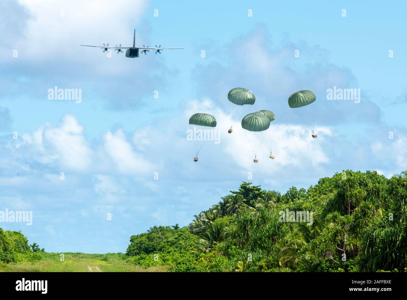 Un U.S. Air Force C-130J Super Hercules gouttes d'air contenant des faisceaux de basse altitude et cadeaux fournitures lors de l'Opération Goutte de Noël 10 décembre 2019 plus de Woleai, États fédérés de Micronésie. Au cours des 68-ans, la U.S. Air Force Operation Christmas Drop a fourni des fournitures essentielles à 56 îles micronésiennes, touchant environ 20 000 personnes à travers un 1,8 million de milles marins carrés. Banque D'Images