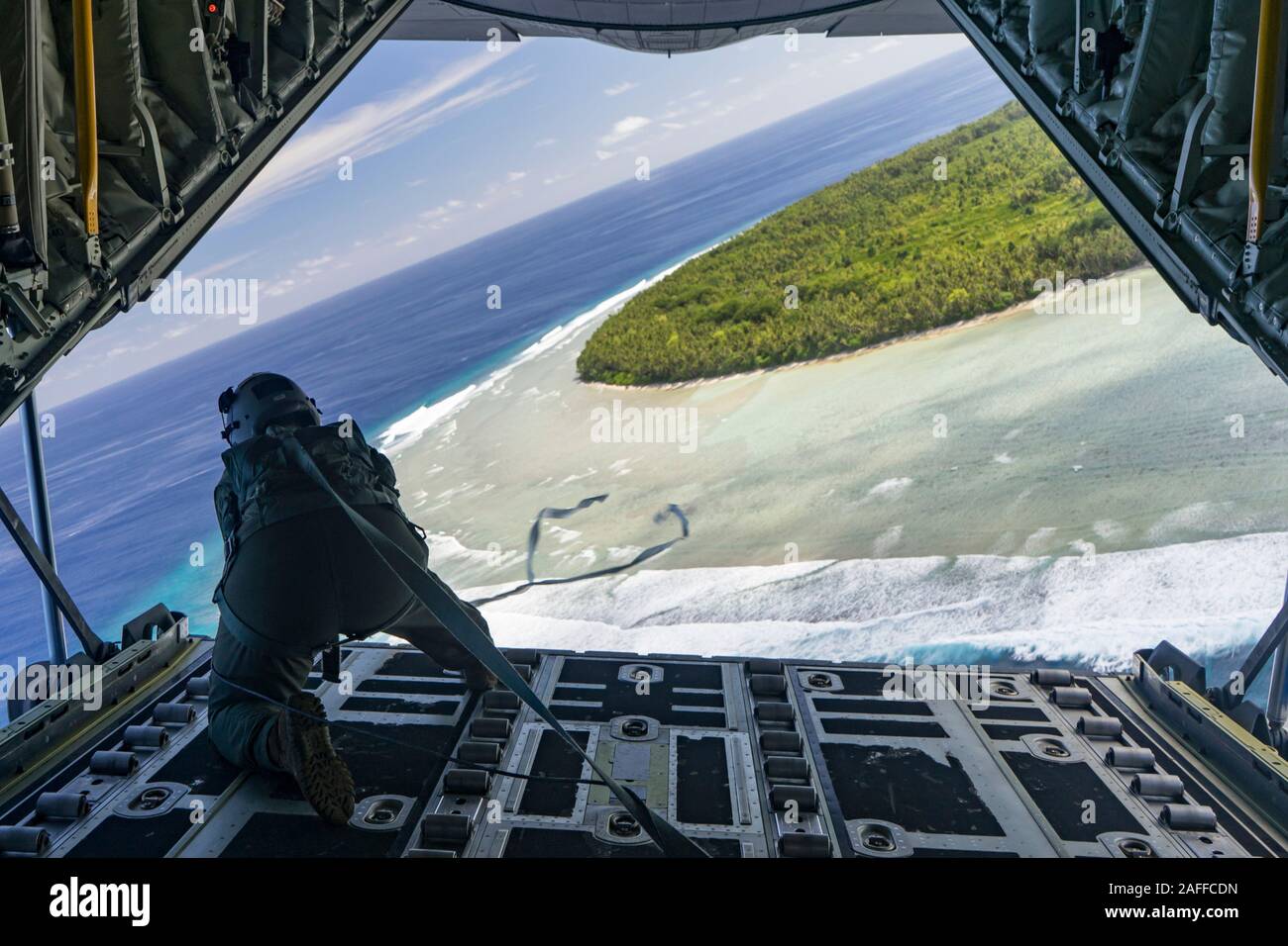 Les aviateurs de l'US Air Force Airman Lauren Shaw, gouttes d'air à basse altitude d'un ensemble contenant des fournitures et cadeaux dans le cadre de l'Opération Goutte de Noël 2019 8 décembre 2019 sur Guam. Au cours des 68 années de fonctionnement, chute de Noël a fourni des fournitures essentielles à 56 îles micronésiennes, touchant environ 20 000 personnes à travers un 1,8 million de milles marins carrés. Banque D'Images