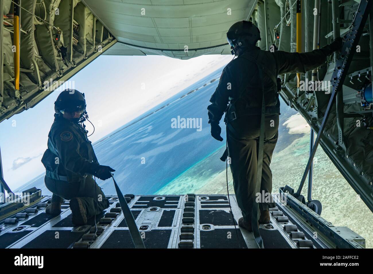 Les aviateurs de l'US Air Force Tech. Le Sgt. Mario Montoya, aviateur et Lauren Shaw, largage à basse altitude, un ensemble contenant des fournitures et cadeaux dans le cadre de l'Opération Goutte de Noël 2019 8 décembre 2019 sur Guam. Au cours des 68 années de fonctionnement, chute de Noël a fourni des fournitures essentielles à 56 îles micronésiennes, touchant environ 20 000 personnes à travers un 1,8 million de milles marins carrés. Banque D'Images