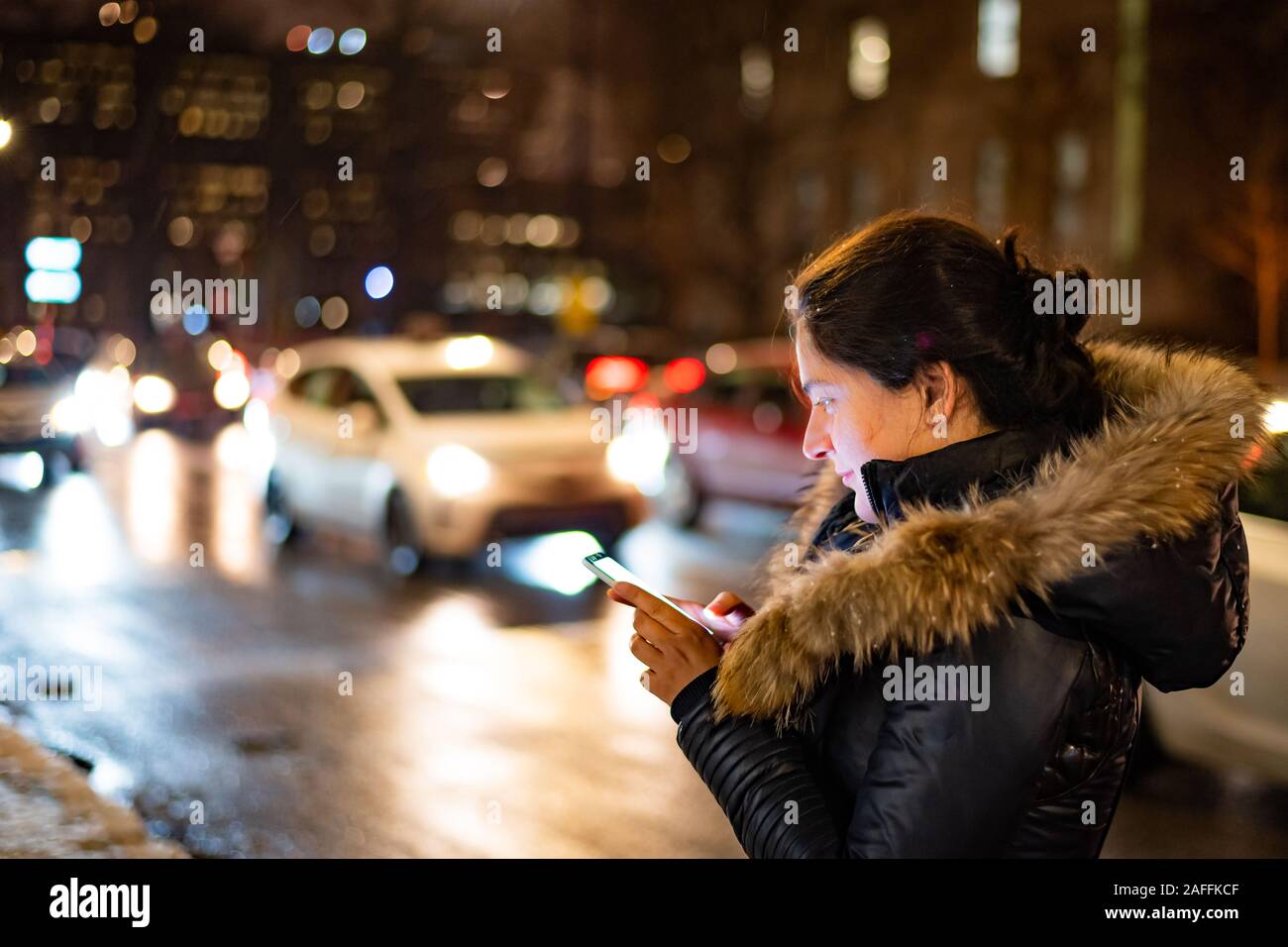 Lady en utilisant son téléphone intelligent dans une ville inconnue debout à côté de la rue de la ville au soir Banque D'Images