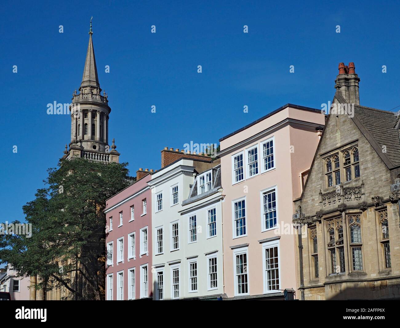 Oxford High Street,avec les façades des bâtiments commerciaux entre les bâtiments de l'Université d'Oxford, et la flèche de l'église All Saints Banque D'Images