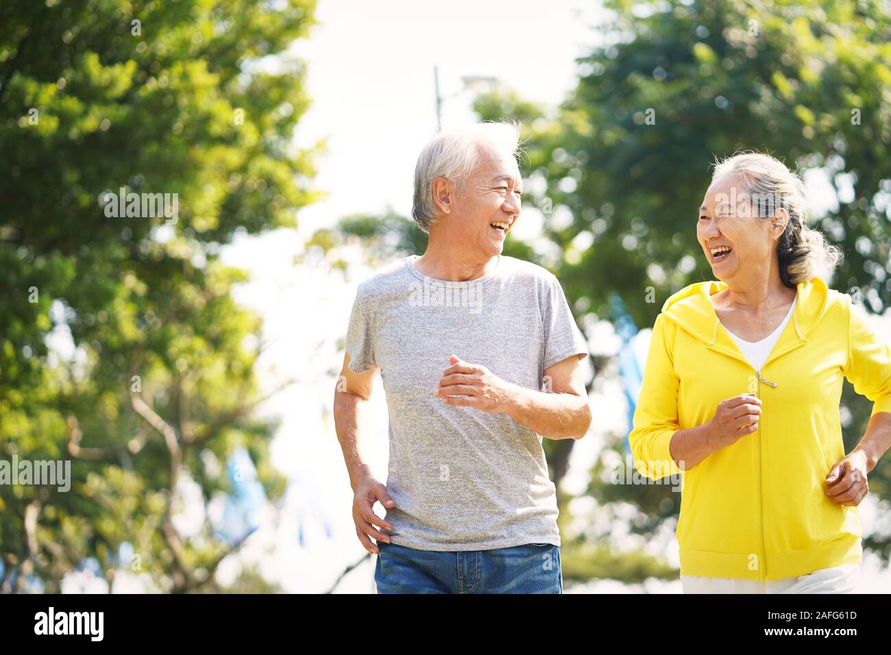 Happy asian vieux couple jogging running outdoors in park Banque D'Images