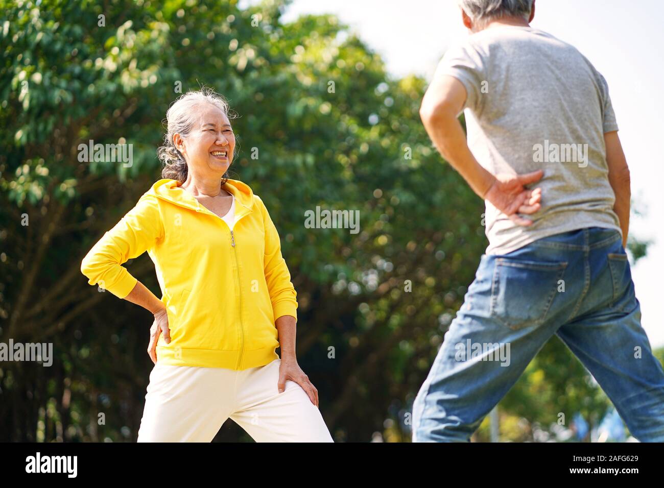 Happy senior asian couple exercising outdoors in park Banque D'Images
