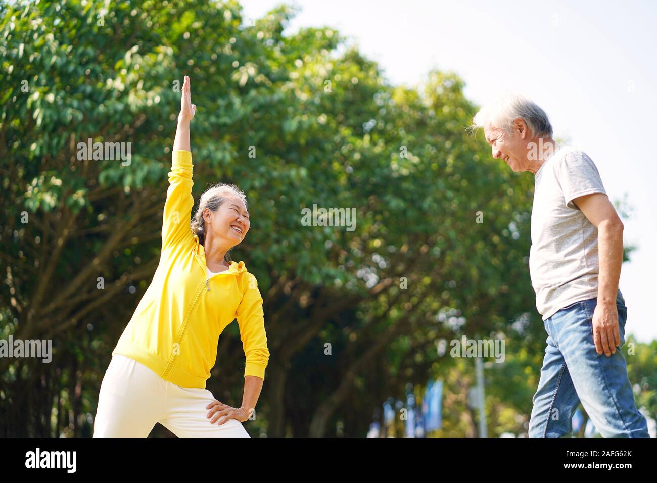 Happy senior asian couple exercising outdoors in park Banque D'Images