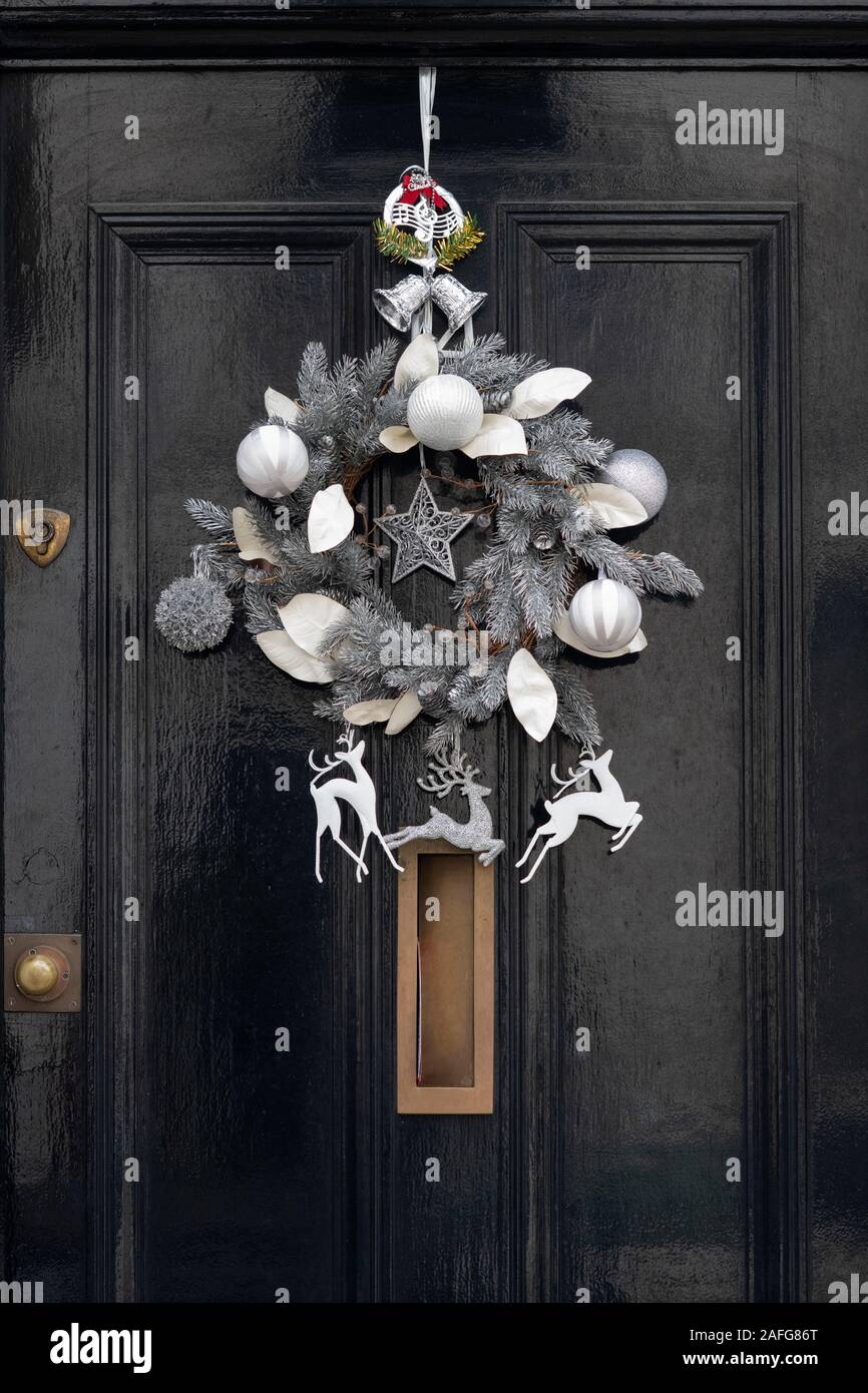 Silver Star et couronne de Noël renne sur une maison en bois noir porte. Londres, Angleterre Banque D'Images