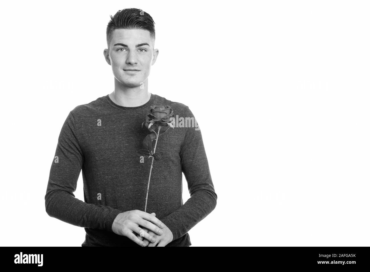Portrait of young man holding red rose Banque D'Images