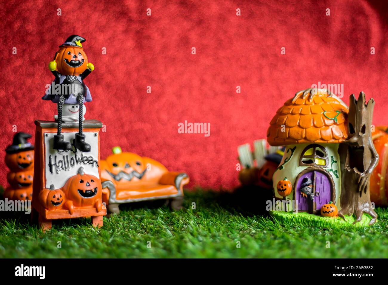 Jouets Halloween sur l'herbe et l'arrière-plan est rouge. Banque D'Images