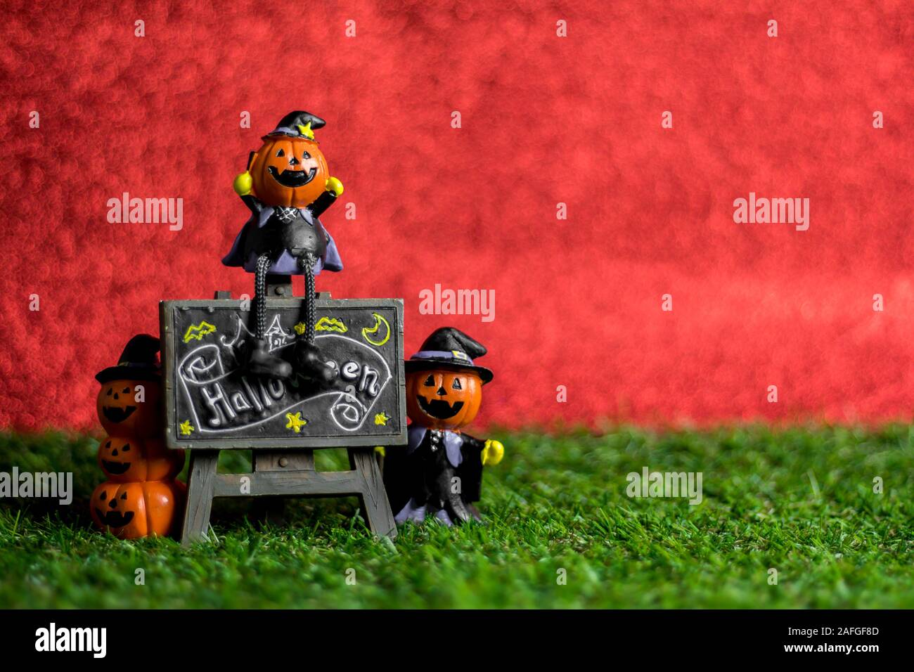 Jouets Halloween sur l'herbe et l'arrière-plan est rouge. Banque D'Images