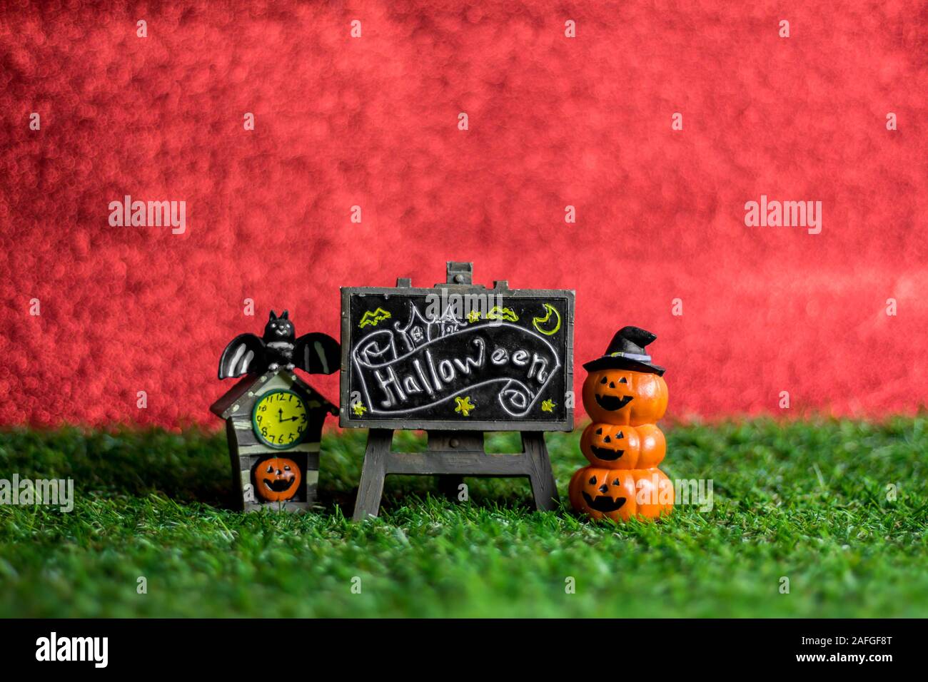 Jouets Halloween sur l'herbe et l'arrière-plan est rouge. Banque D'Images