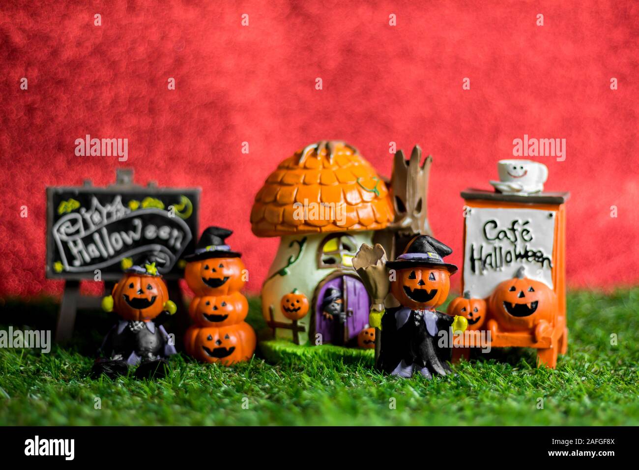 Jouets Halloween sur l'herbe et l'arrière-plan est rouge. Banque D'Images