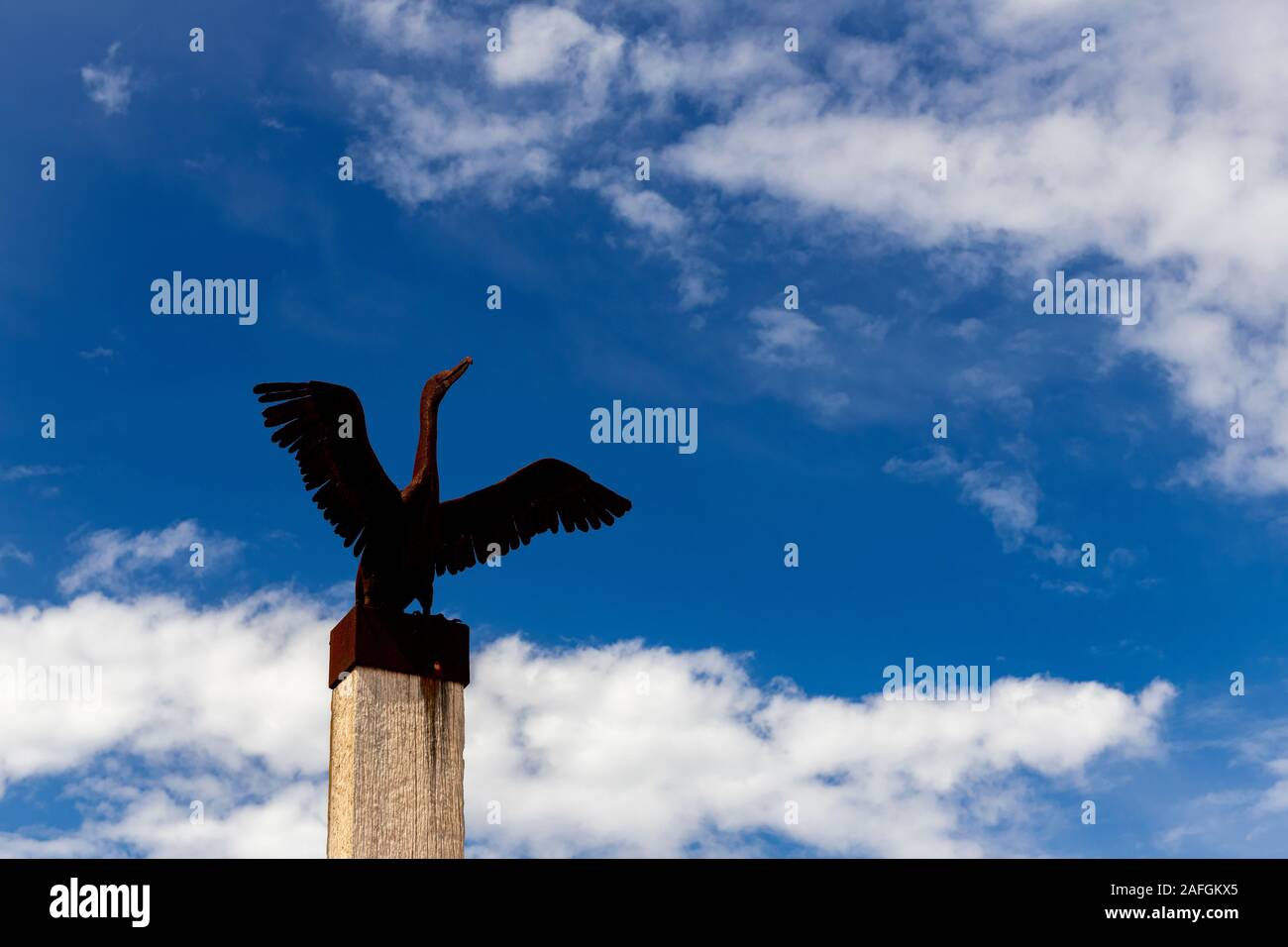 Une sculpture extérieure d'un oiseau en métal rouillé se trouve sur un poteau en bois à la jetée de Port Germein en Australie méridionale Banque D'Images