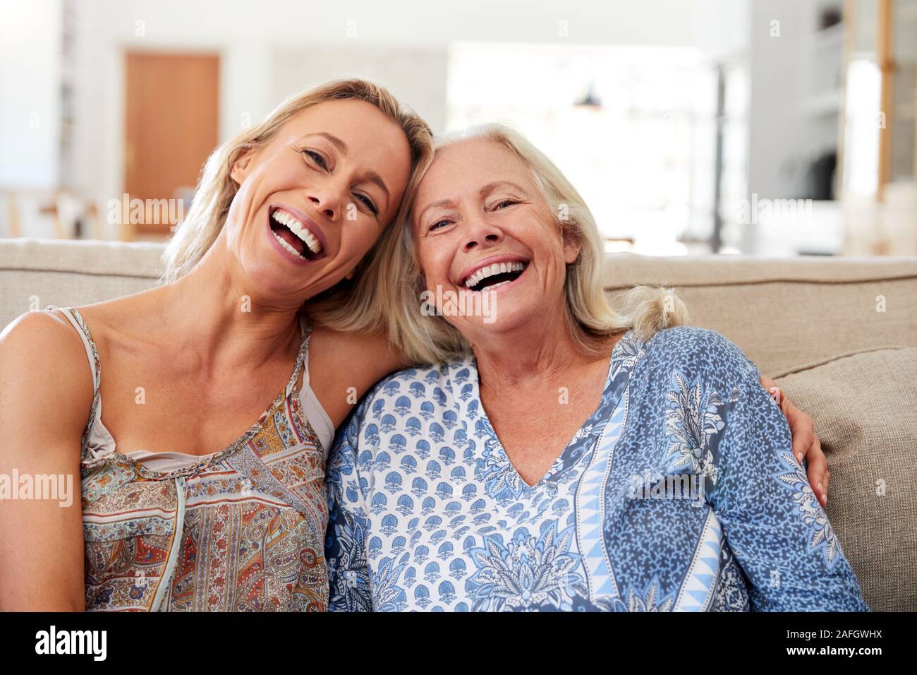 Portrait Of Smiling Mother and Daughter Relaxing On Sofa At Home Banque D'Images