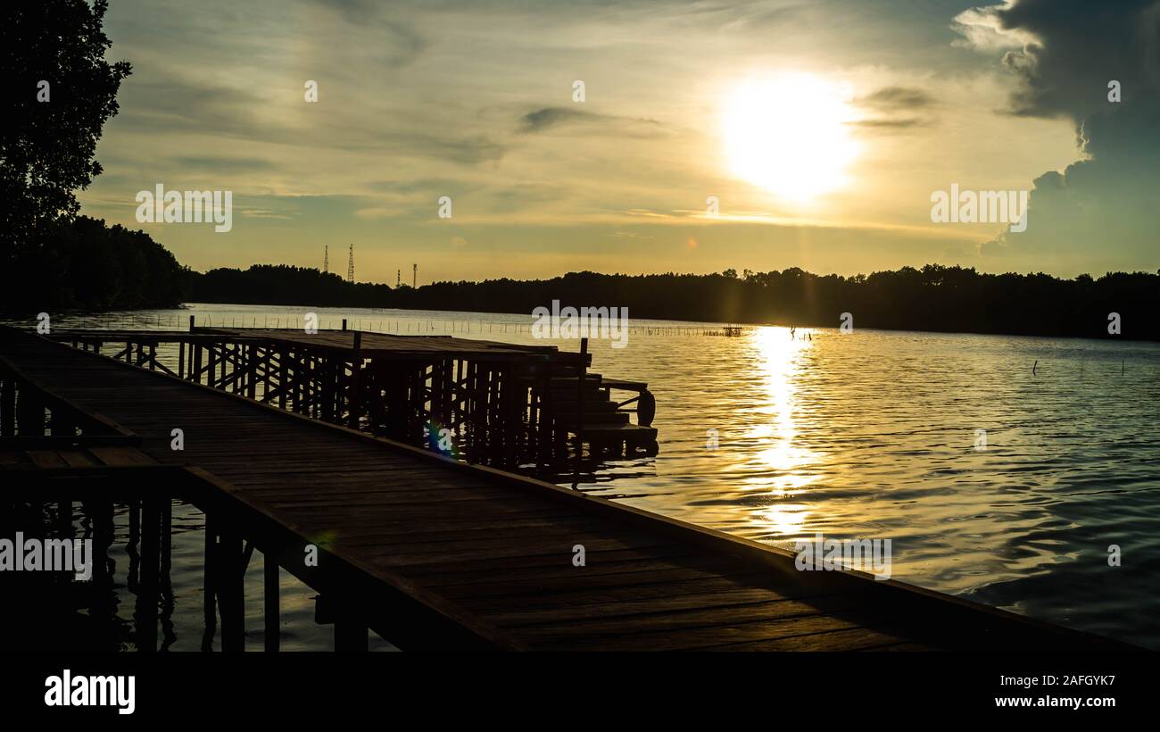 JWooden effectuée à partir de la jetée (Eusideroxylon zwageri ULINE) sur la rivière au coucher du soleil à Parc National de Kutai, Indonésie Banque D'Images