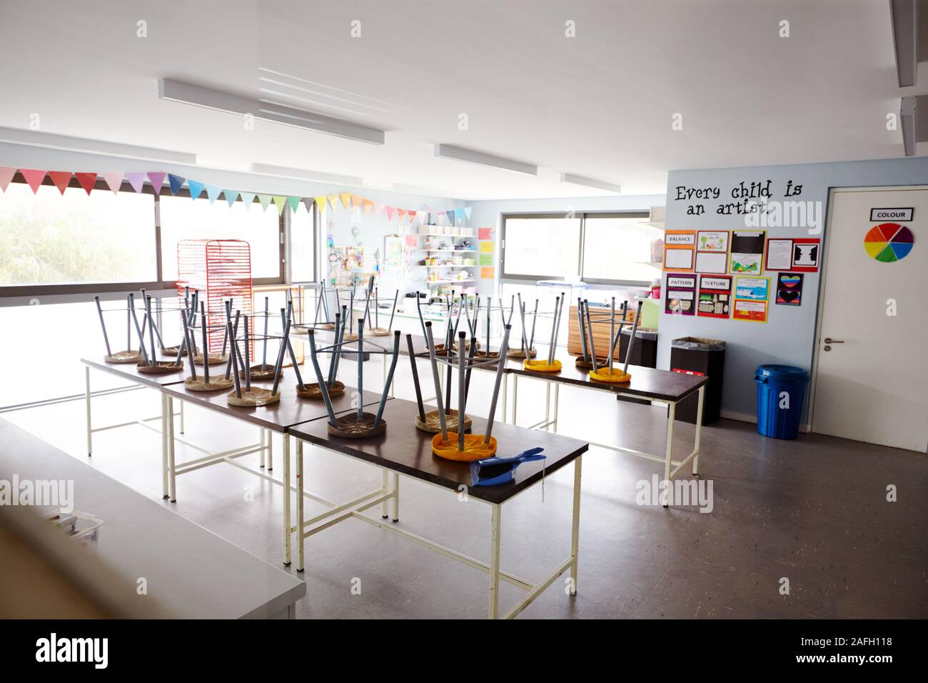 Classe d'arts plastiques vides à l'école primaire avec des chaises empilées sur les tables Banque D'Images