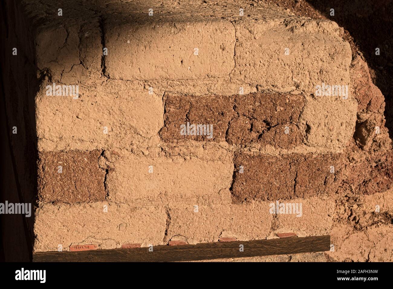 Section d'un mur de brique de boue rouge rouille du temple cananéen ruines à tel hazor en Israël montrant la texture et le motif détail y compris des morceaux de str Banque D'Images