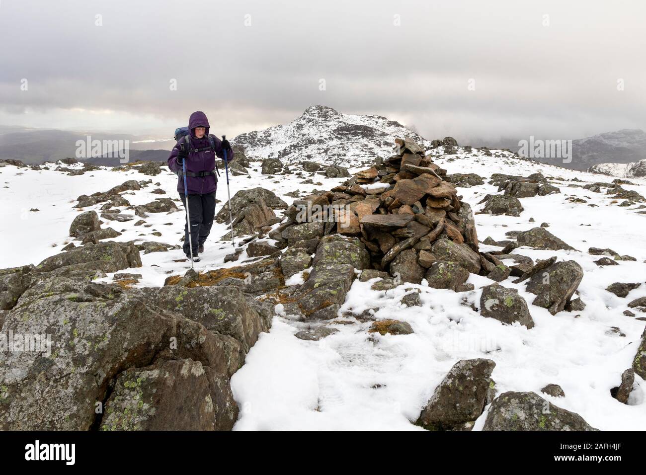 L'approche du sommet de Walker Thunacar Knott en hiver avec la montagne de Harrison Stickle en toile de fond, Lake District, Cumbria, Royaume-Uni Banque D'Images