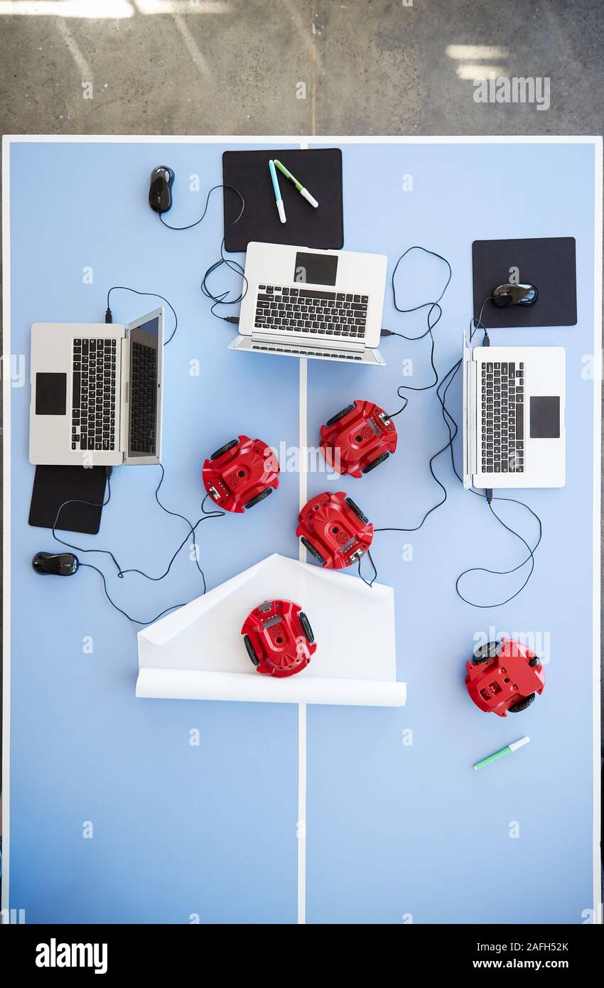 Vue aérienne d'ordinateurs portables et les véhicules robotisés sur le tableau à l'école Classe de codage informatique Banque D'Images