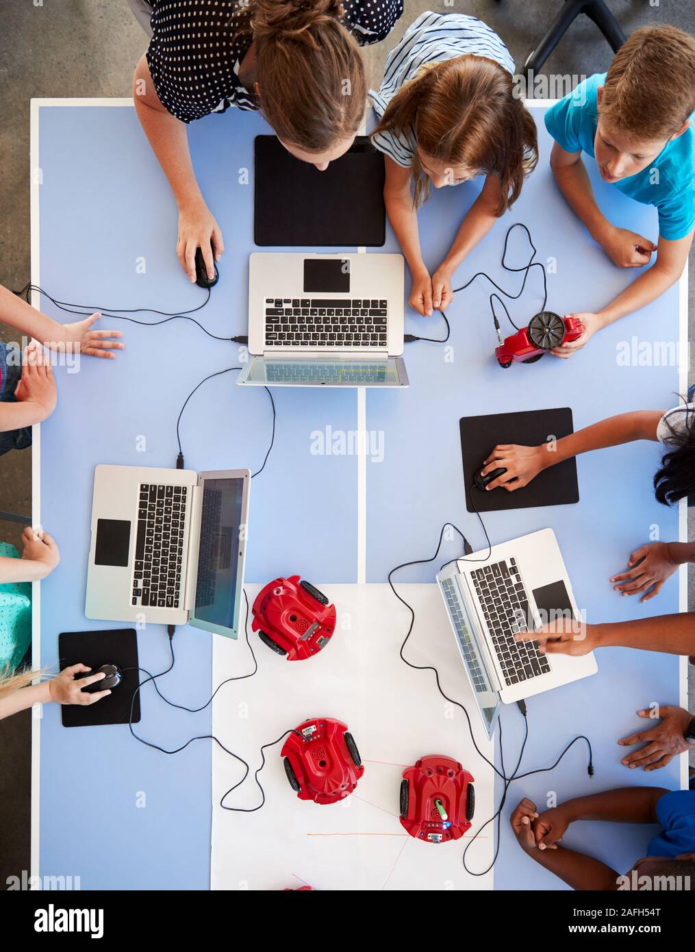Vue supérieure de l'ordinateur après l'école les élèves dans l'apprentissage de la classe Codage Véhicule Robot Programme Banque D'Images