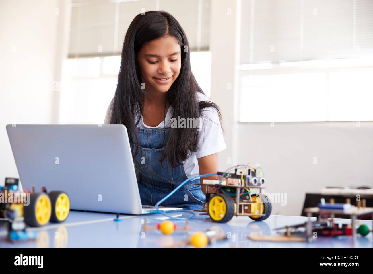 Étudiante Building et de programmation Robot Véhicule en classe après l'École de codage informatique Banque D'Images