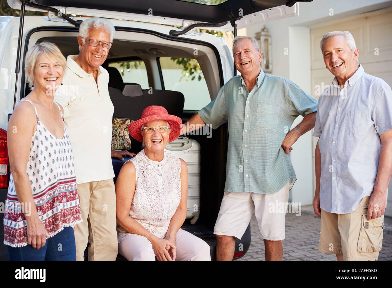 Portrait of Senior Friends Loading Assurance dans coffre de voiture sur le point de partir pour des vacances Banque D'Images