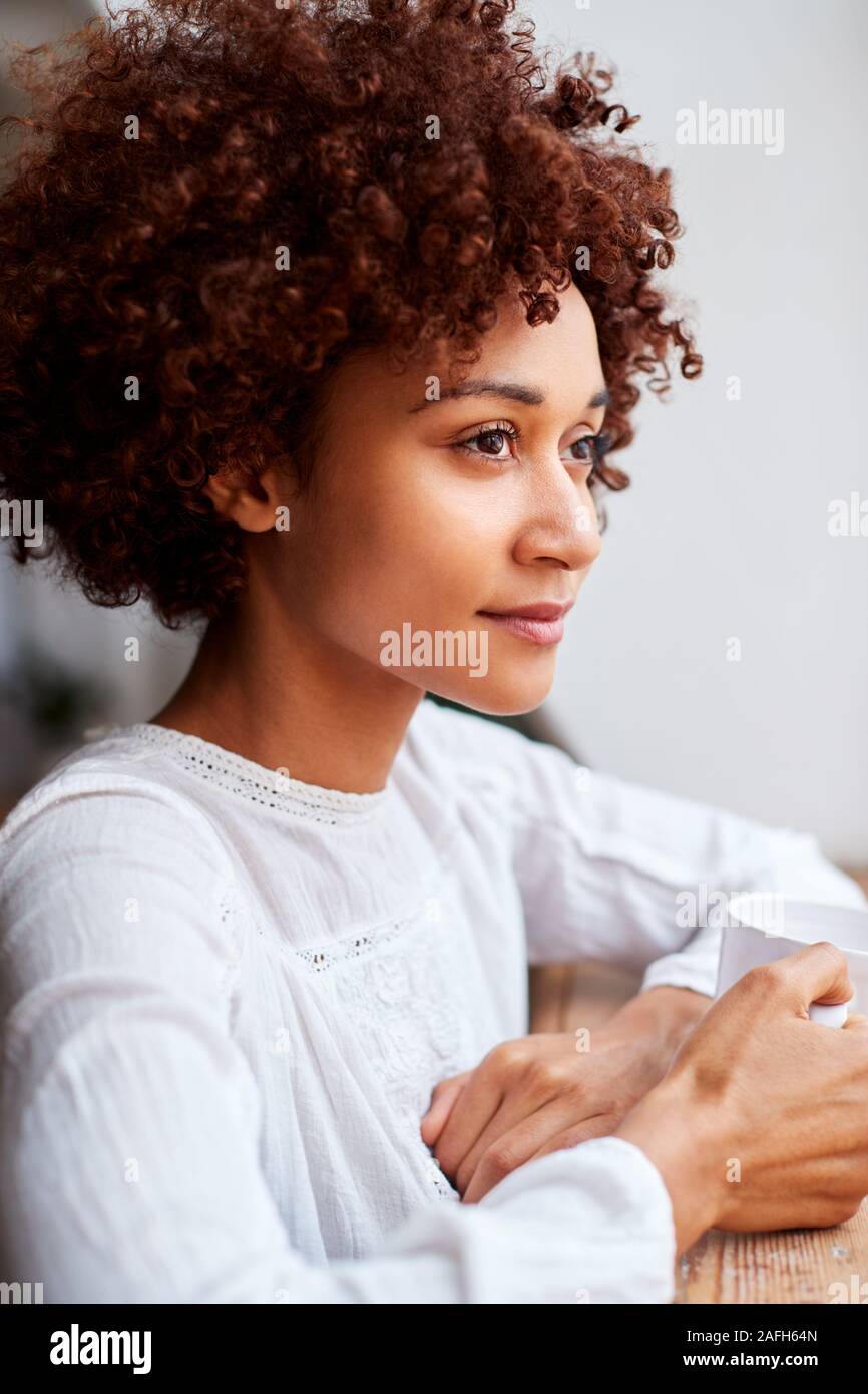 Young Woman Relaxing In Loft avec boisson chaude Banque D'Images