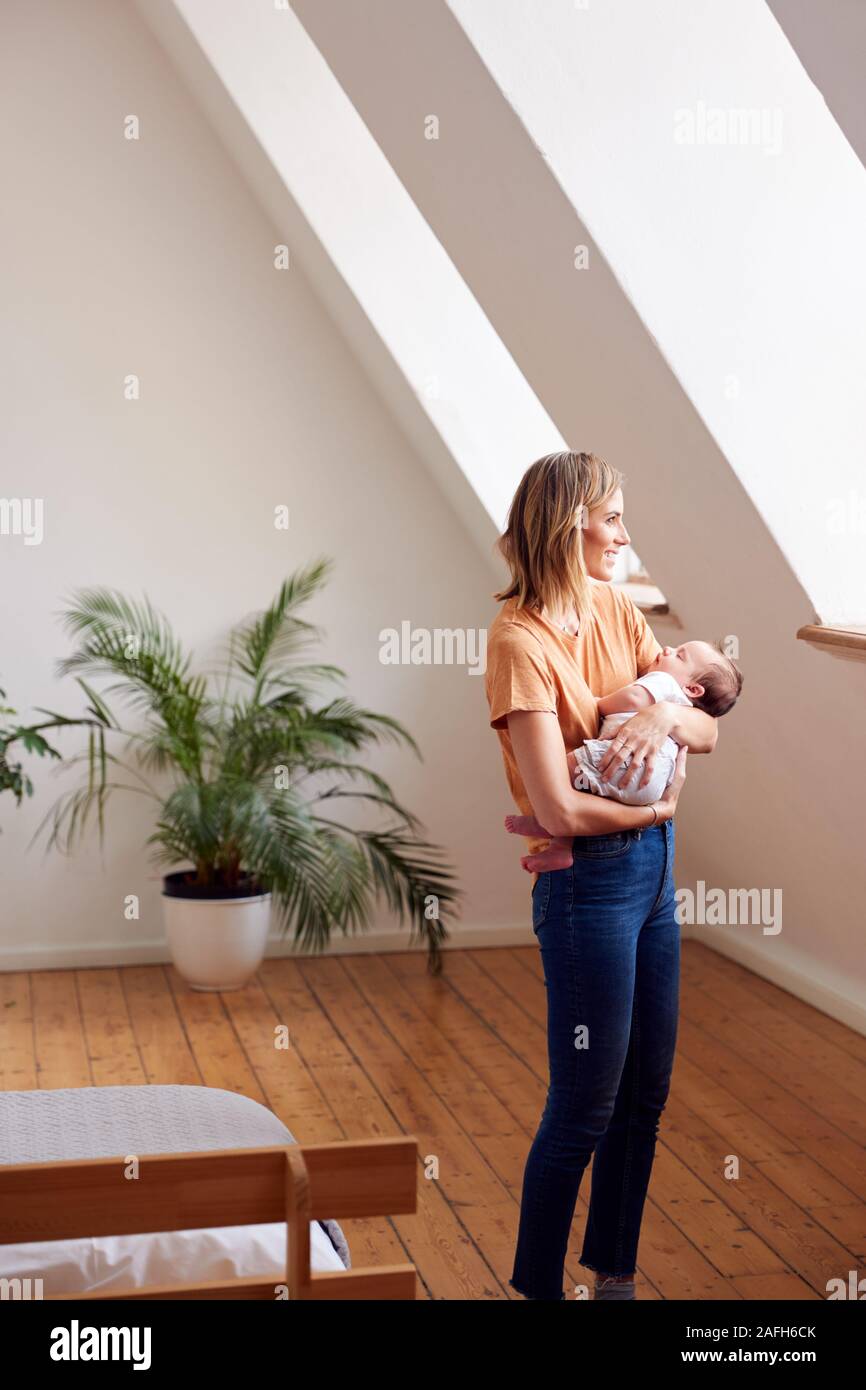Loving Mother Holding Newborn Baby à la maison dans cet appartement Loft Banque D'Images