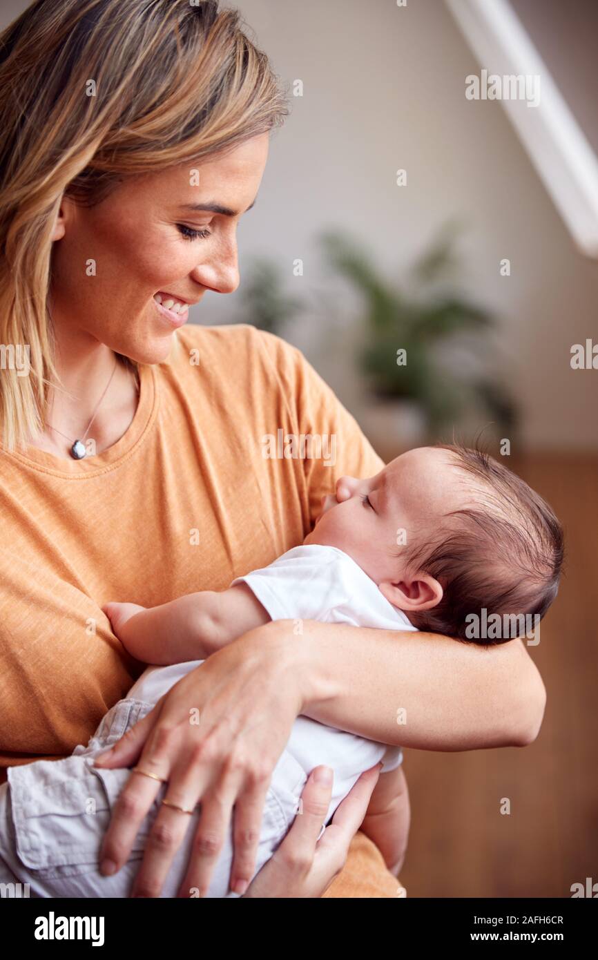 Loving Mother Holding Newborn Baby à la maison dans cet appartement Loft Banque D'Images
