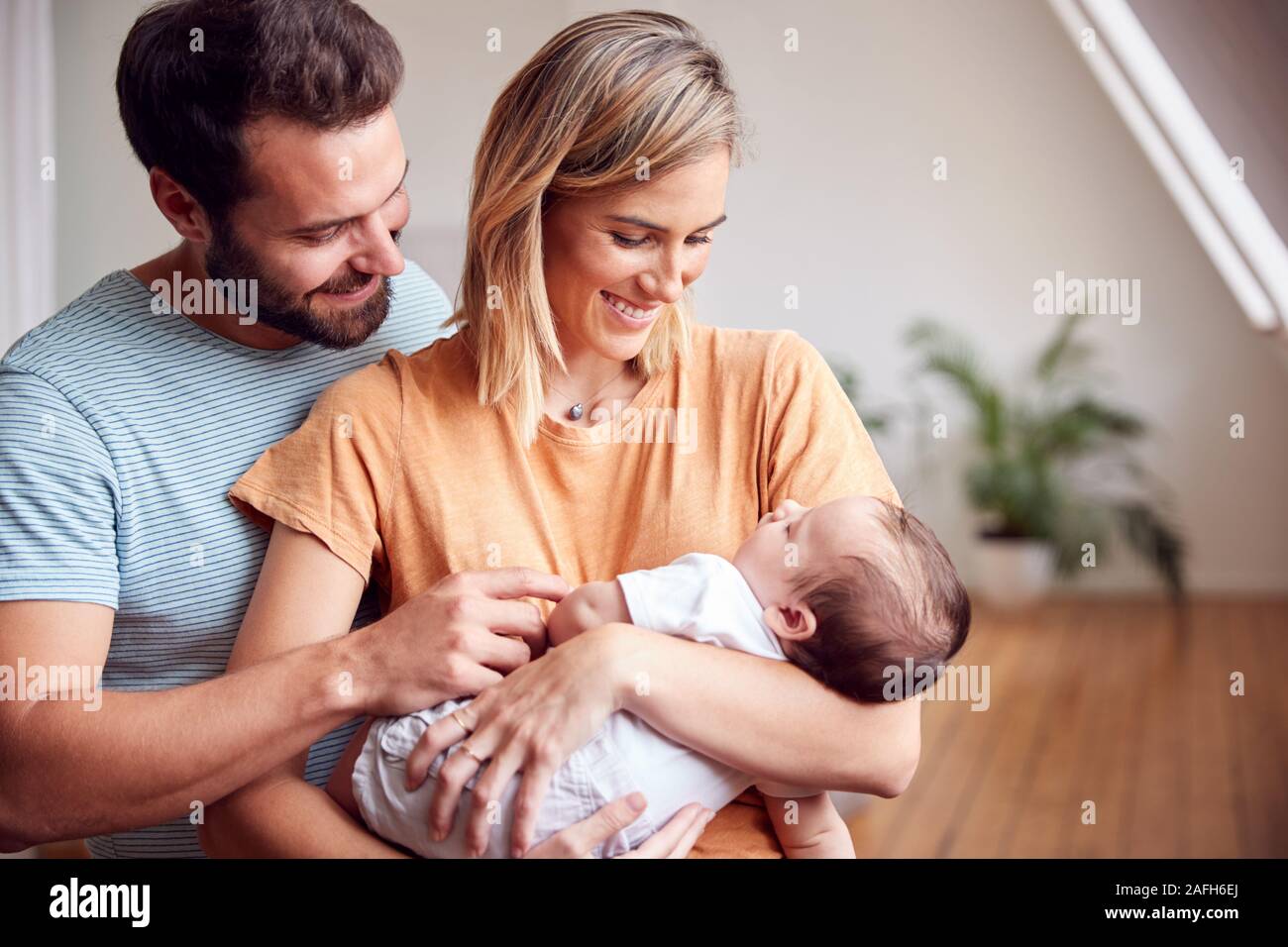 Les parents aimants Holding Newborn Baby à la maison dans cet appartement Loft Banque D'Images