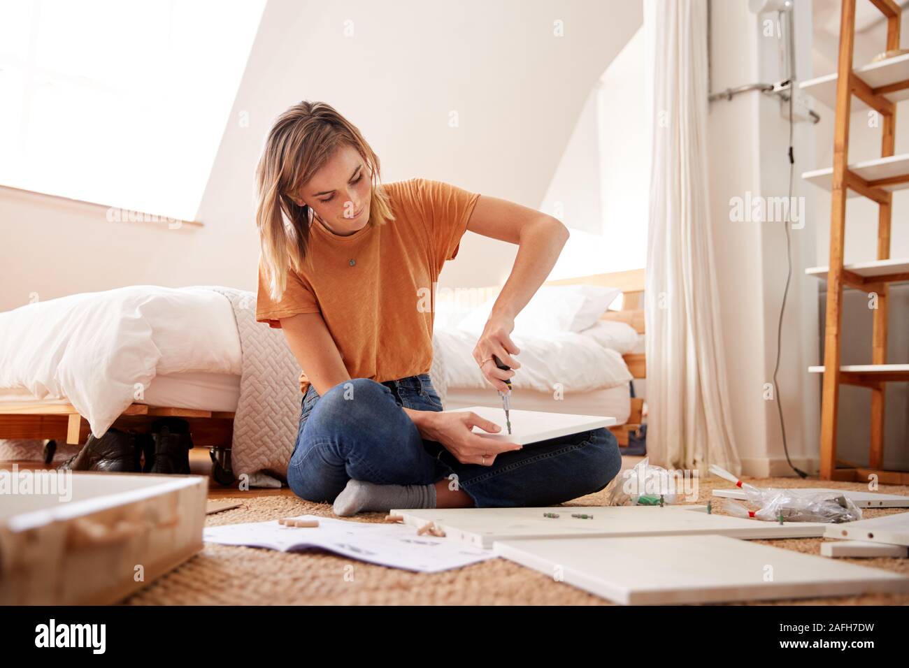 Woman in New Home Mettre Ensemble de meubles à assembler soi-même Banque D'Images