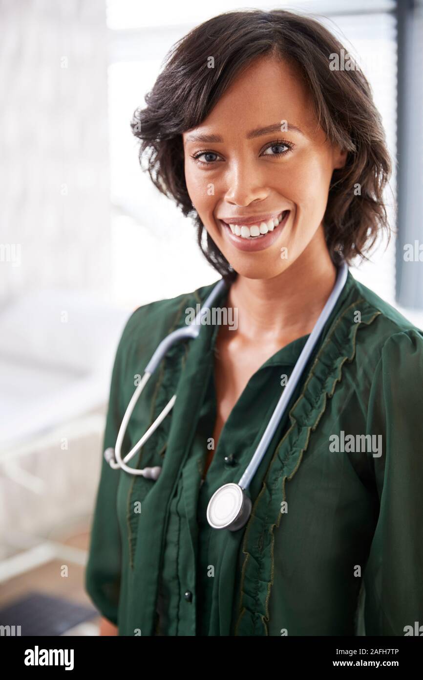 Portrait Of Smiling Female Doctor with Stethoscope Standing By Desk In Office Banque D'Images