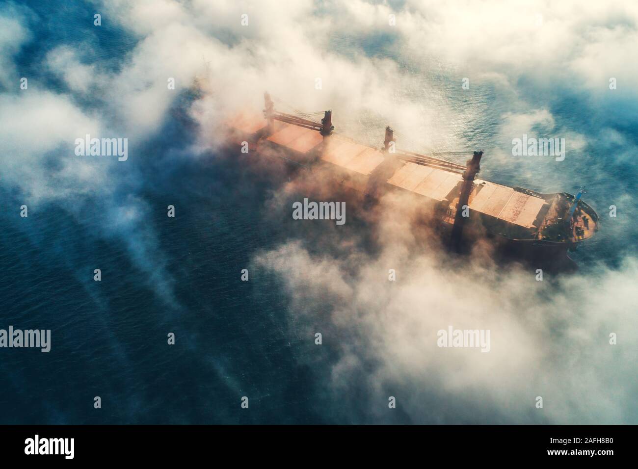 Grues de navire de charge et de silhouettes en brouillard de mer, bateau grue travaillant pour la livraison des conteneurs de livraison. Banque D'Images