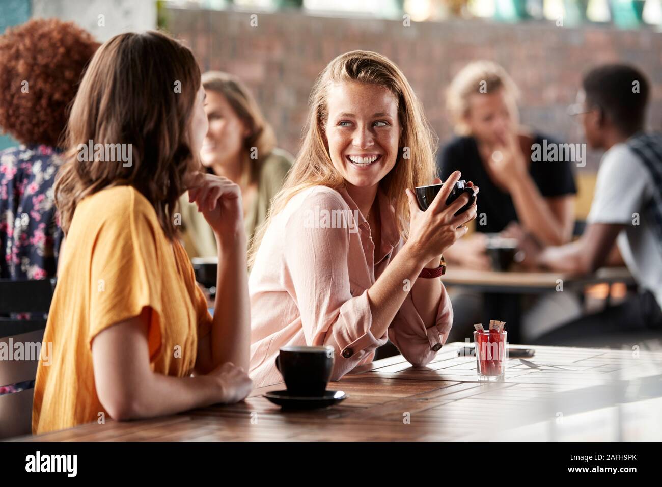 Deux amis assis à table dans un café et parler Banque D'Images