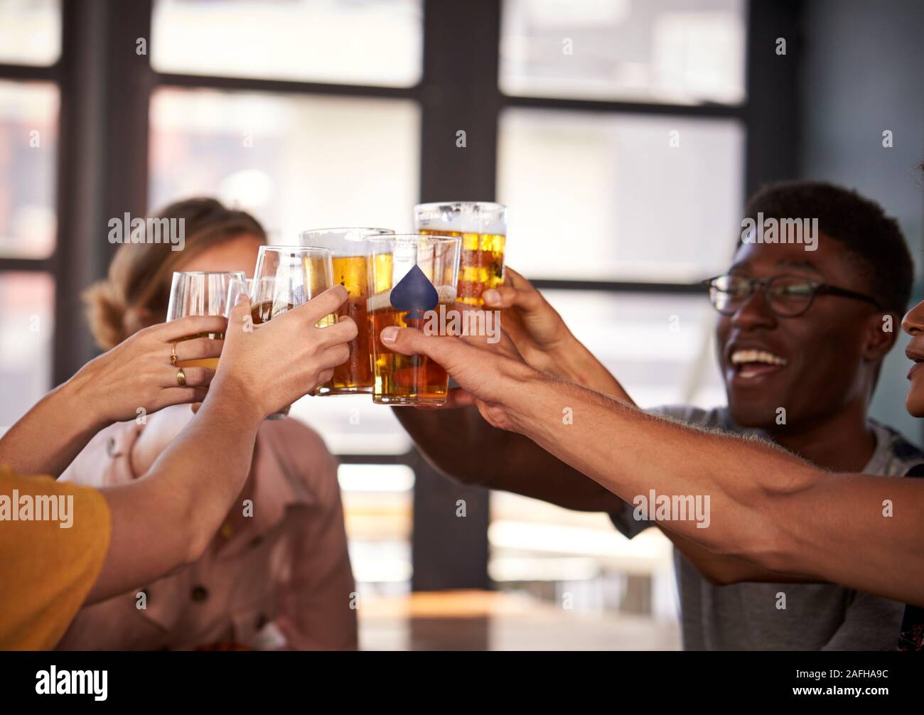 Groupe de jeunes Réunion Amis de boissons et de faire un toast en Restaurant Banque D'Images