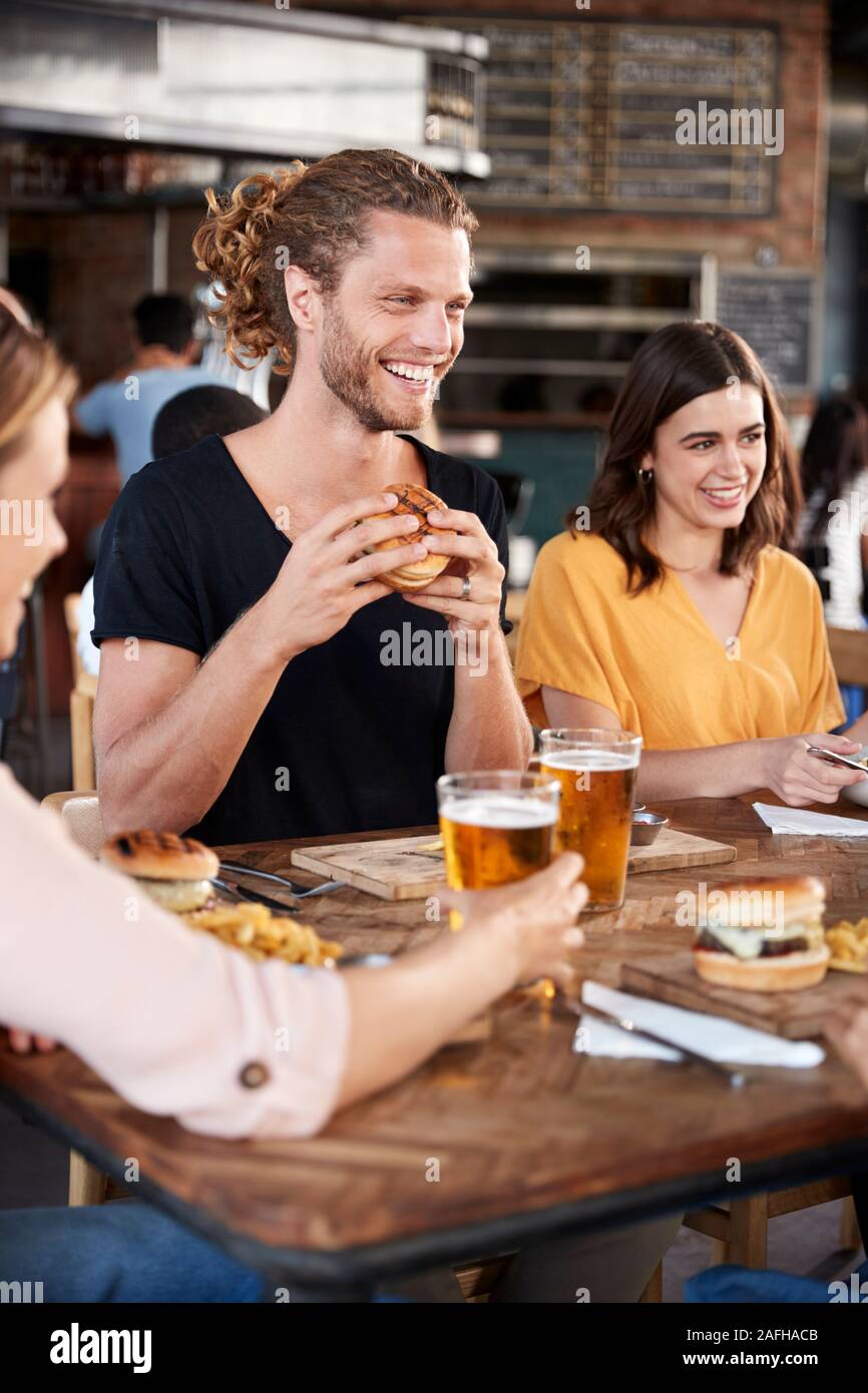 Groupe de jeunes amis réunion pour des boissons et de la nourriture dans le restaurant Banque D'Images