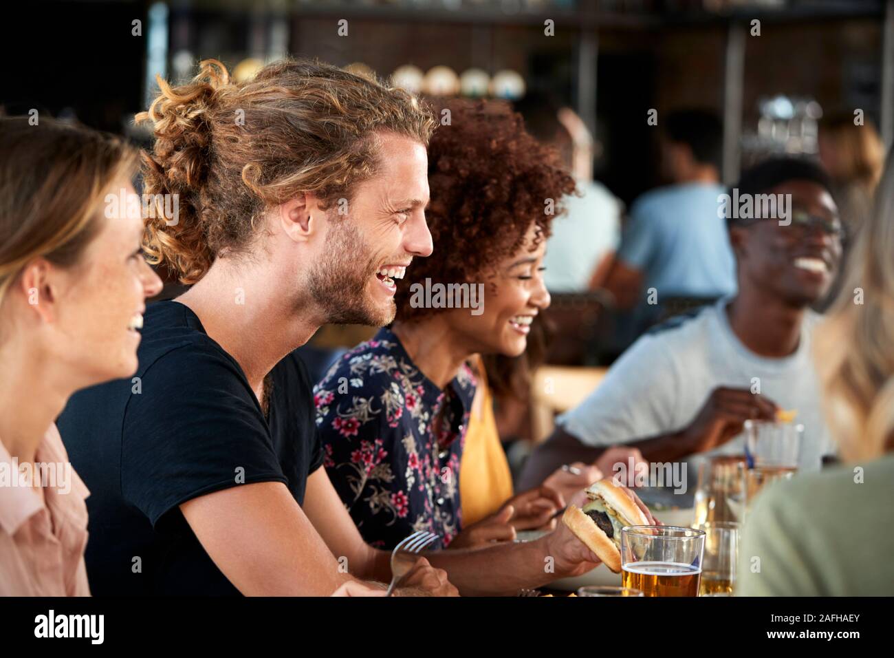 Groupe de jeunes amis réunion pour des boissons et de la nourriture dans le restaurant Banque D'Images