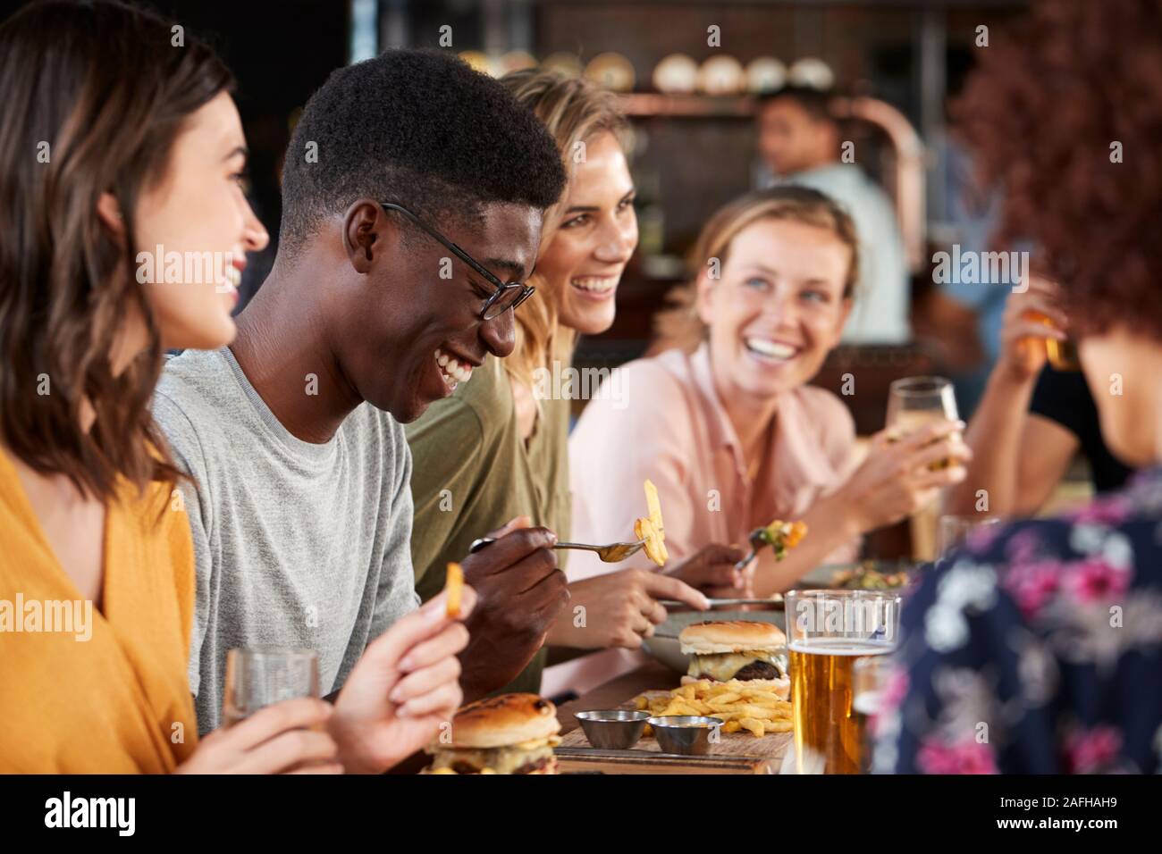 Groupe de jeunes amis réunion pour des boissons et de la nourriture dans le restaurant Banque D'Images