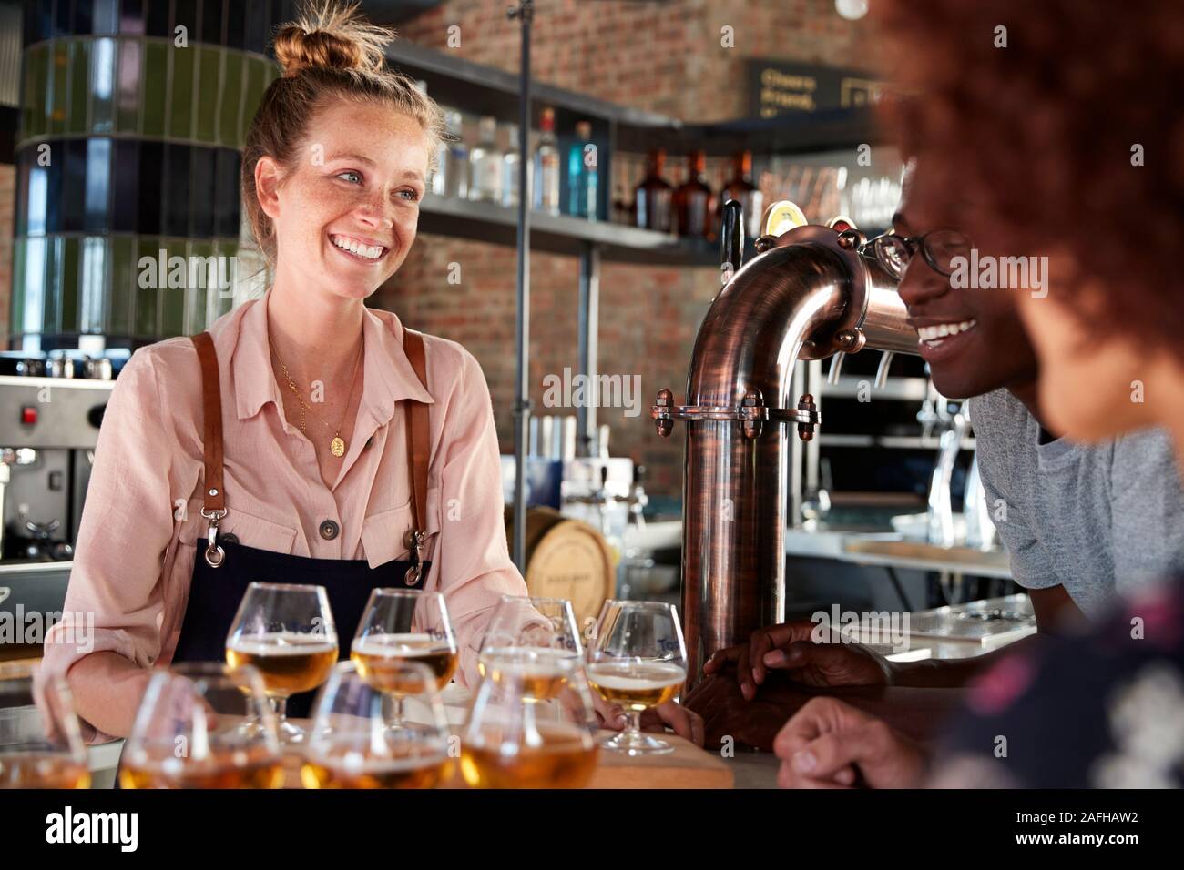 Waitress Serving Groupe des Amis de la bière au bar de dégustation Banque D'Images