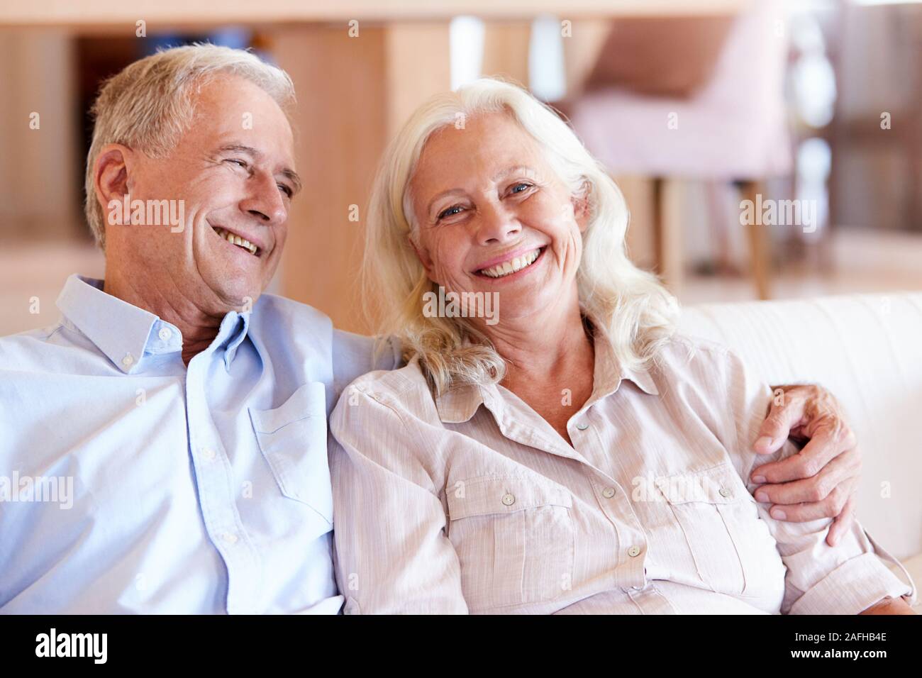 Happy senior couple sitting at home blanc enlacés, vue de face, Close up Banque D'Images