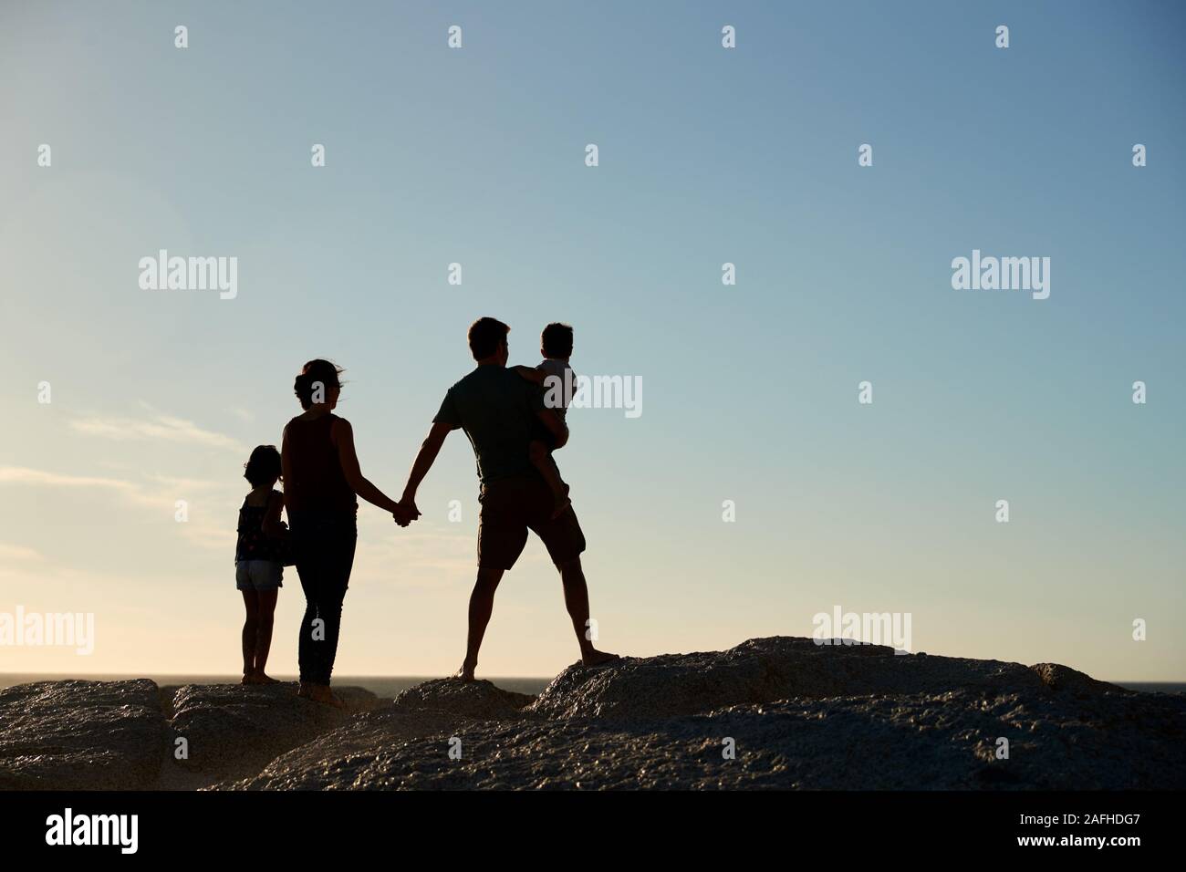 Mid adult parents et deux enfants pré-ado beach admiring view, pleine longueur, silhouette Banque D'Images