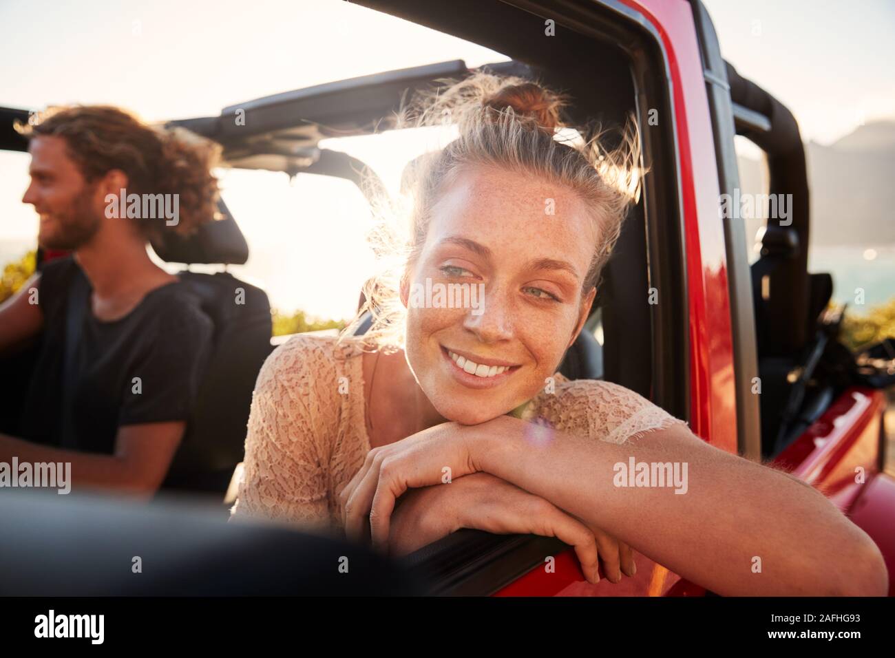 Couple blanc millénaire sur un voyage sur la route la conduite en voiture à toit ouvert, les femmes s'appuyant sur porte de la voiture, Close up Banque D'Images