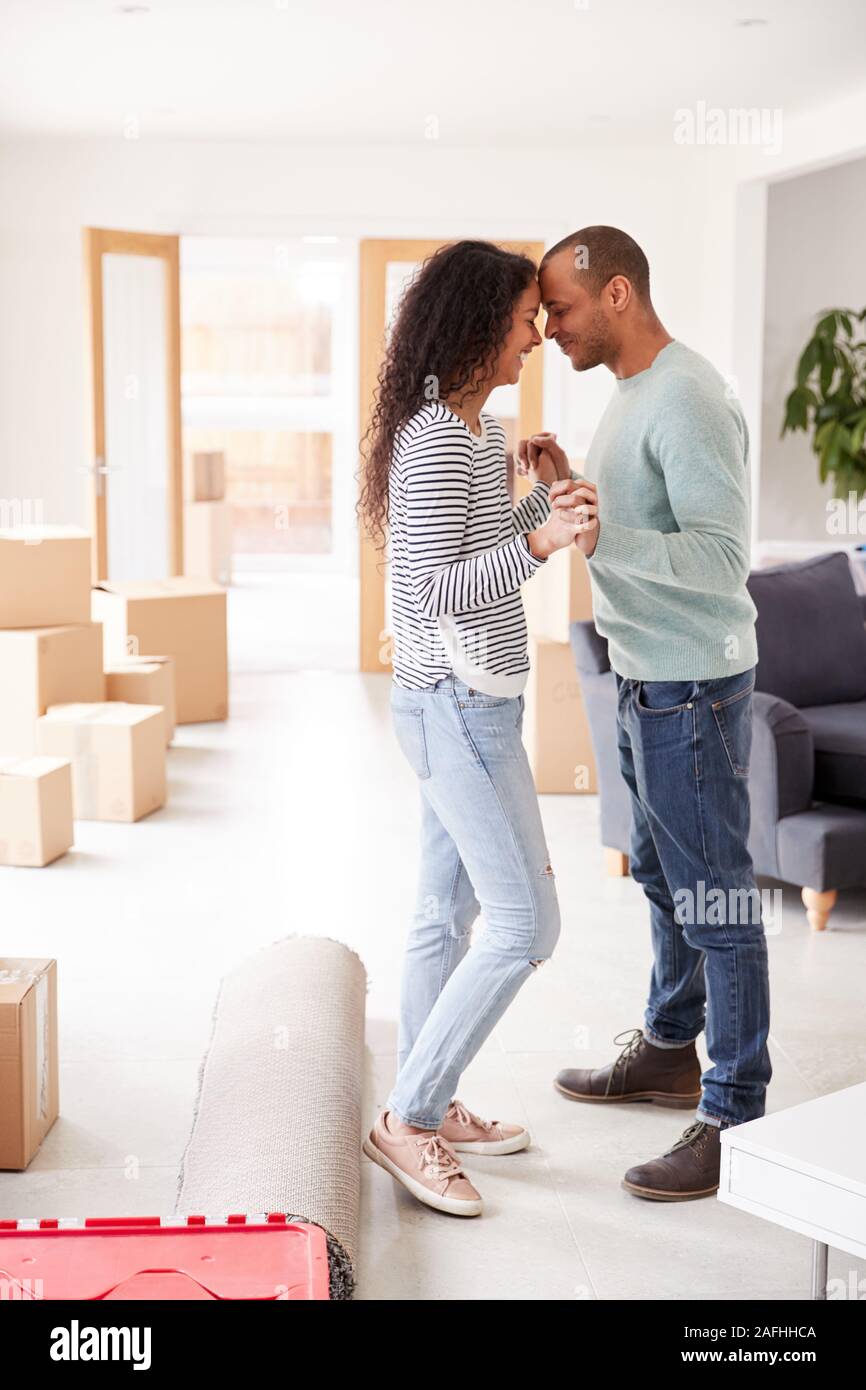 Couple aimant entouré par des boîtes à New Home le jour du déménagement Banque D'Images