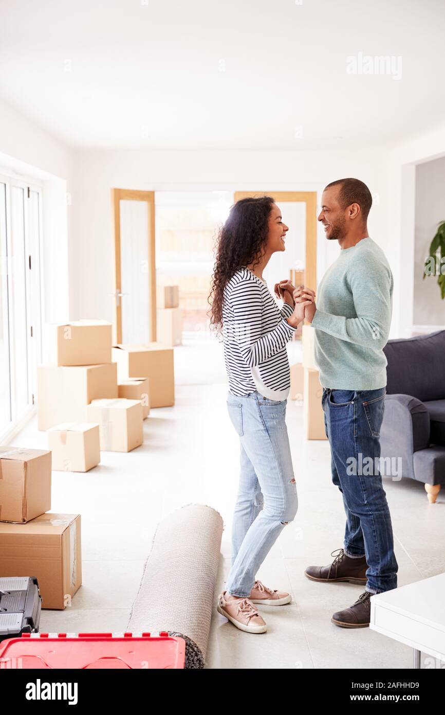 Couple aimant entouré par des boîtes à New Home le jour du déménagement Banque D'Images