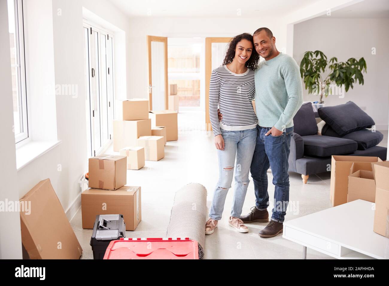 Portrait de couple aimant entouré par des boîtes à New Home le jour du déménagement Banque D'Images