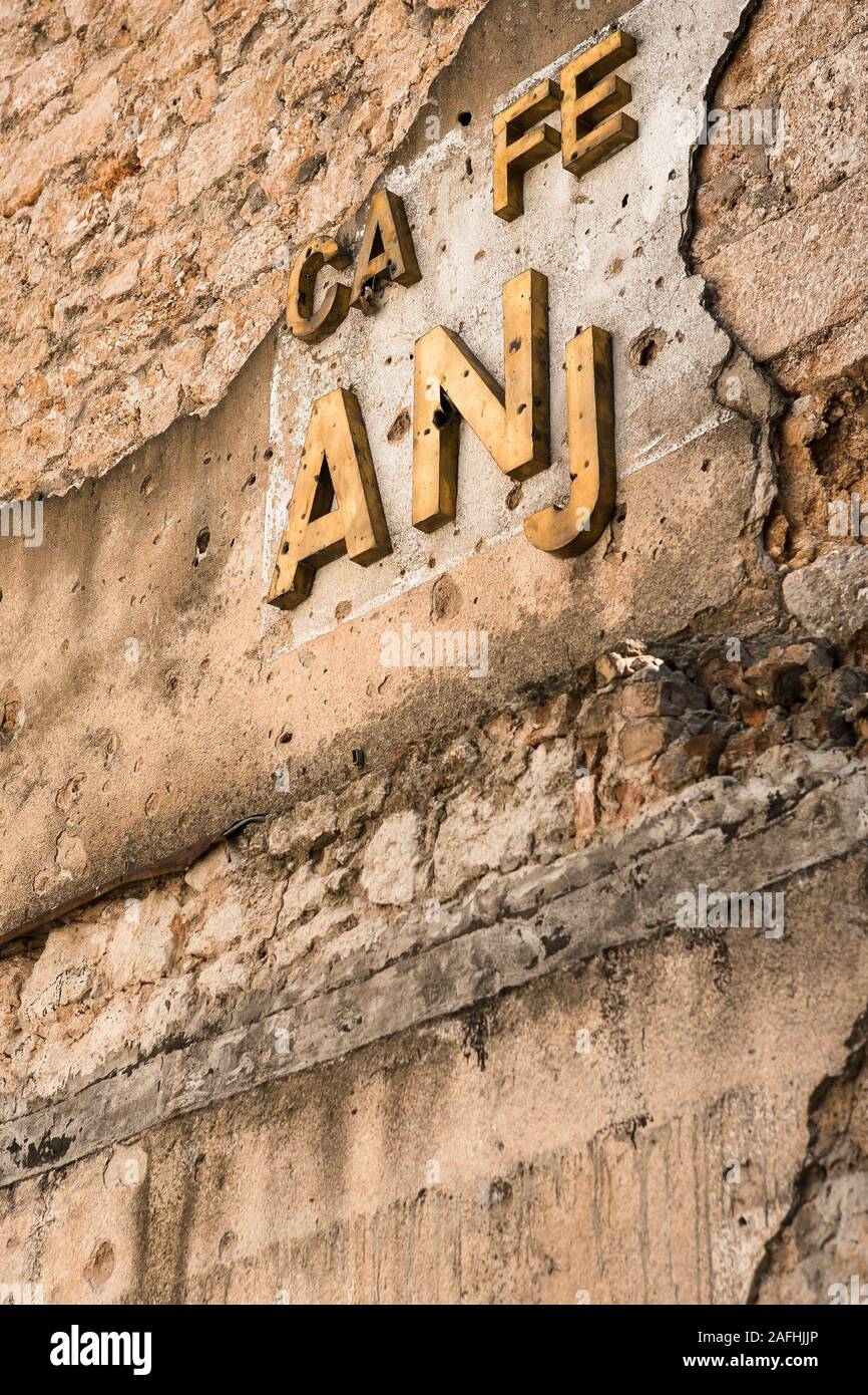 Mostar, Bosnie-Herzégovine, 13 Octobre 2007 : Un caffe détruit signe sur un mur d'un bâtiment plein de vieux trous d'obus dans la région de Mostar, Bosnie-Herzégovine Banque D'Images