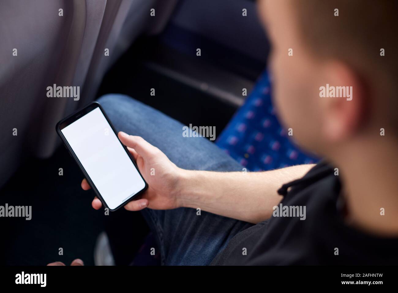 Close Up Of Male passager assis en train avec billet numérique sur téléphone mobile Banque D'Images