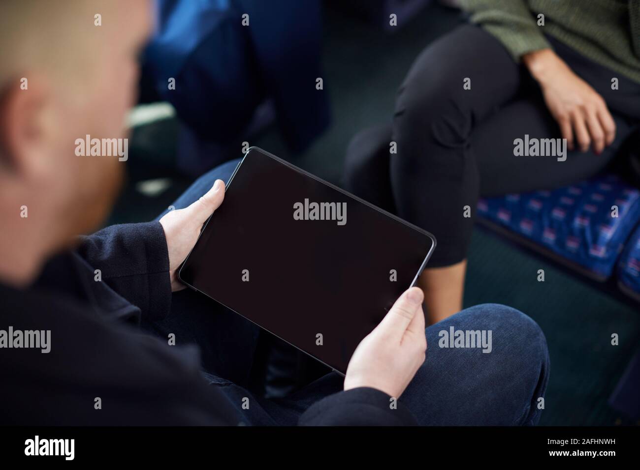 Close Up Of Male passager assis en train avec billet numérique sur Tablet Computer Banque D'Images