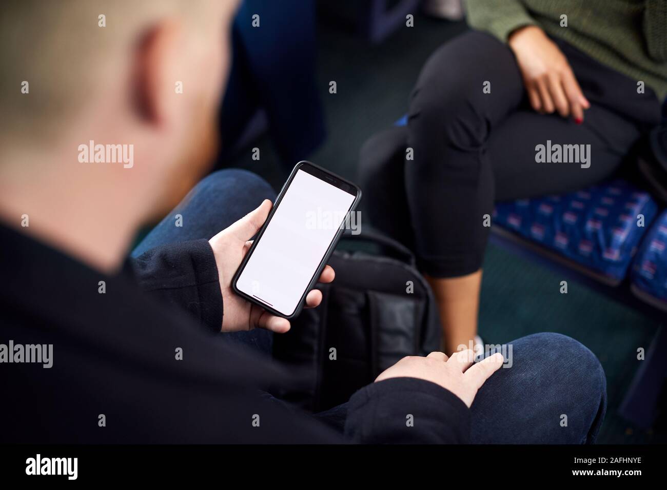 Close Up Of Male passager assis en train avec billet numérique sur téléphone mobile Banque D'Images